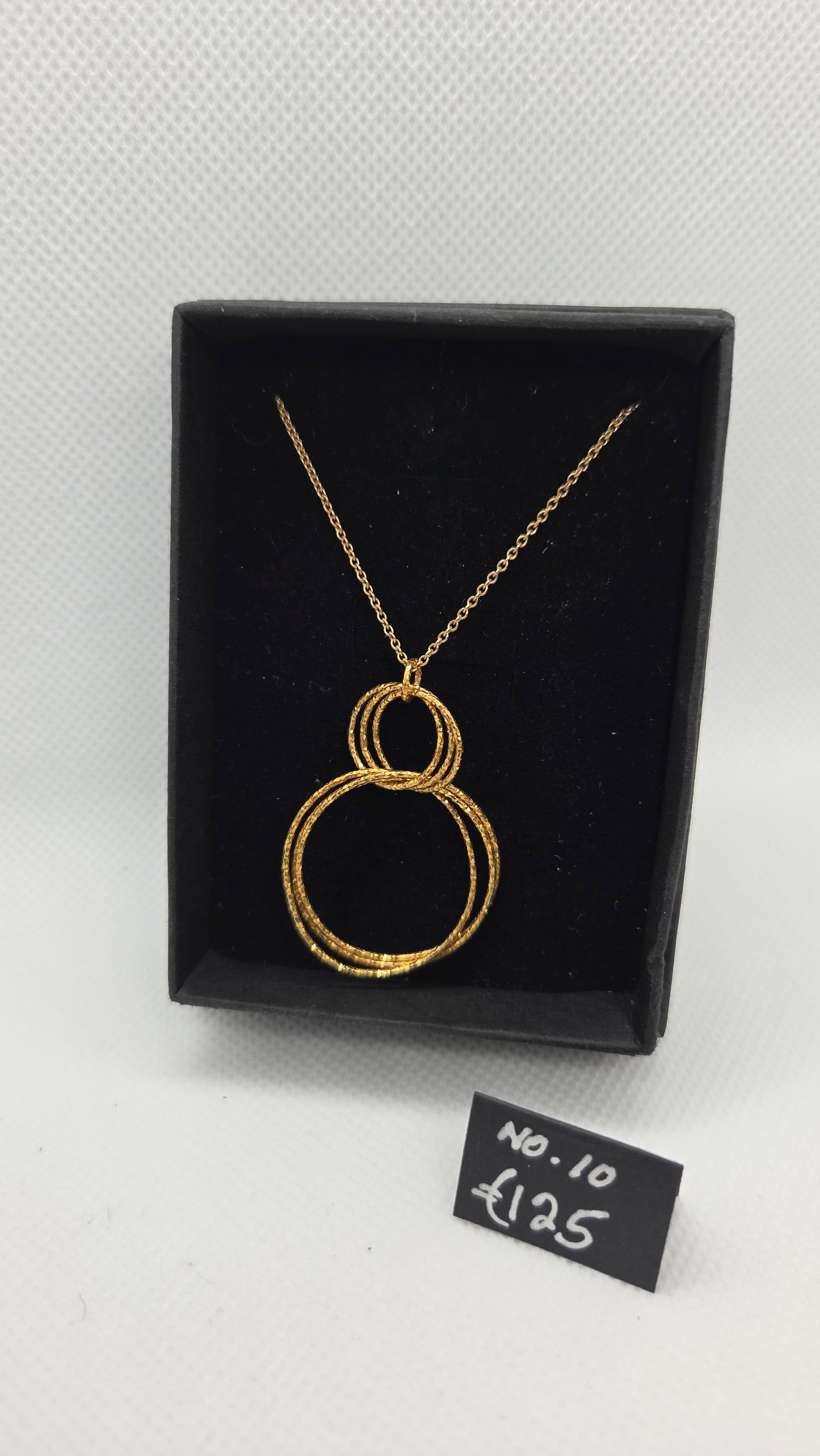 Gold chain with interlocking gold circle pendant