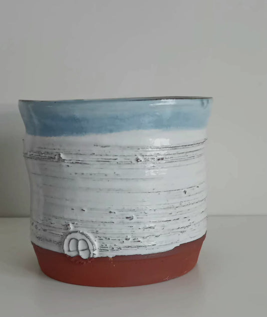 Ceramic white vase with light blue rim.