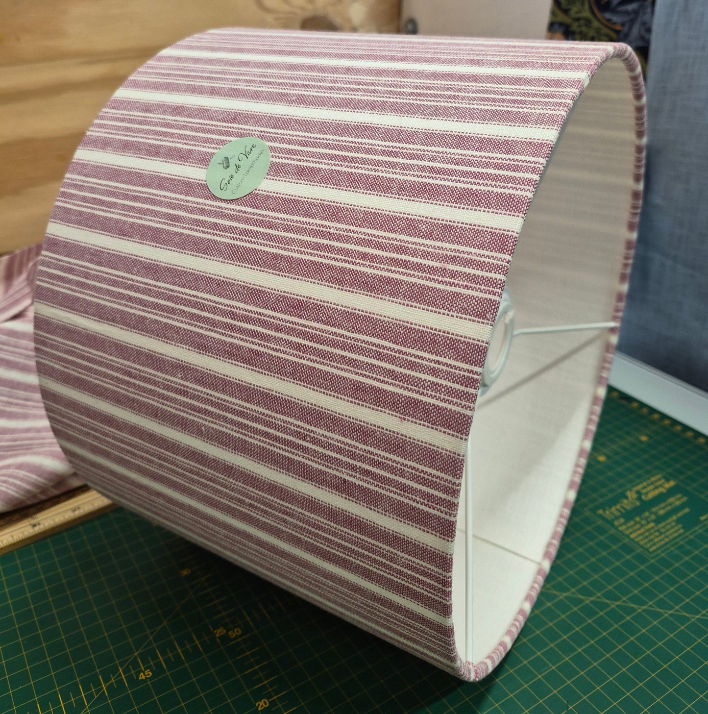 A 30cm drum shade covered in a cotton striped fabric, lined with a linen lining.